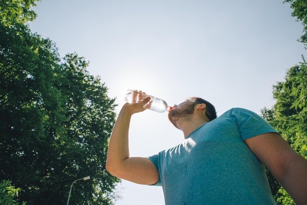 Man drinking water in hot summer day copy space