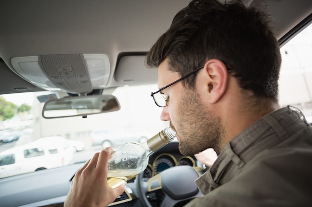 Photo man drinking wine while driving