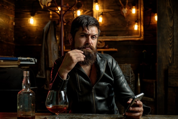 Man drinks brandy or whiskey bearded man wearing suit and drinking whiskey brandy or cognac sommelie...