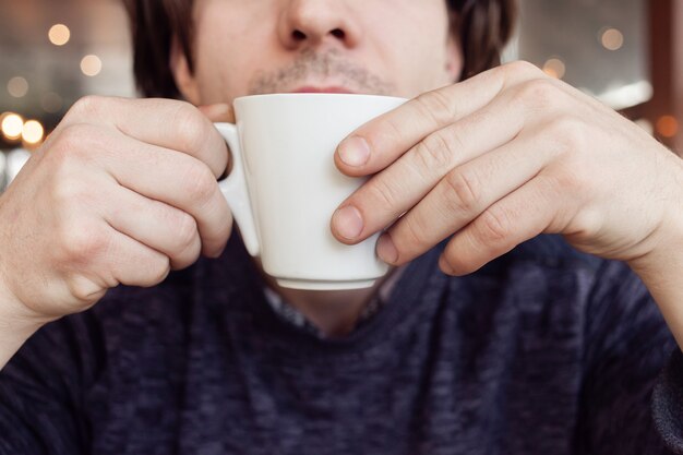 A man drinks coffee in a cafe, a restaurant