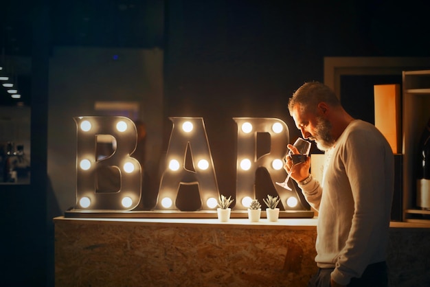 L'uomo beve vino in un bar