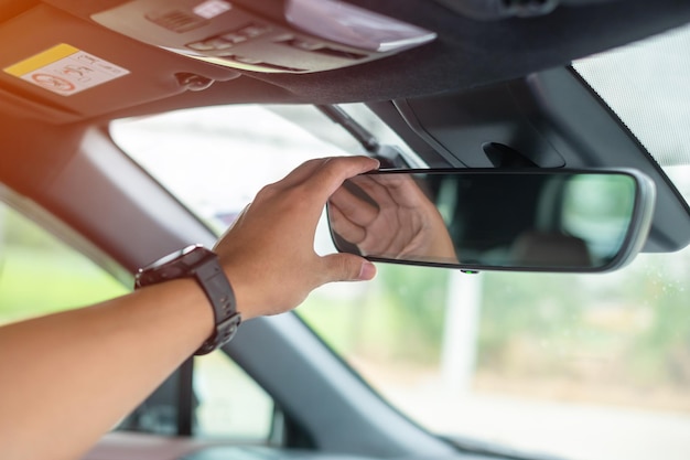 Photo man driver adjusting rear view mirror a car journey trip and safety transportation concepts