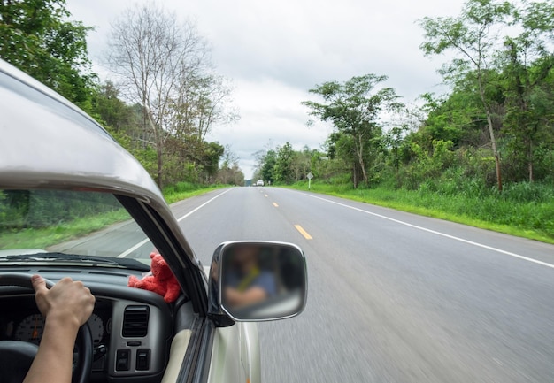 Man driver holding steering wheel right on rural road