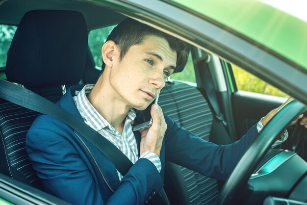 Man driver talking on a phone in the car