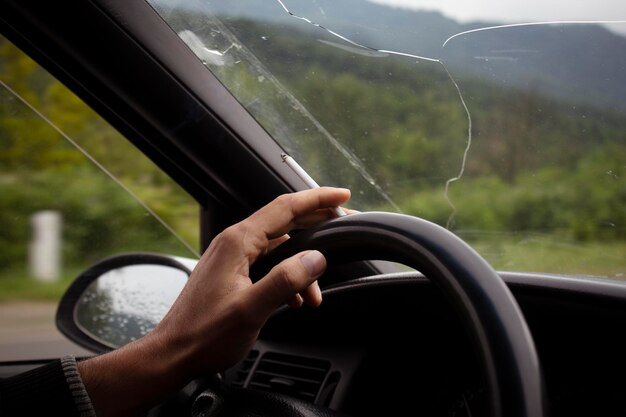 A man drives a car and smokes