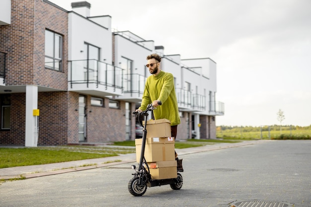 Man drives electric scooter with cardboard packages