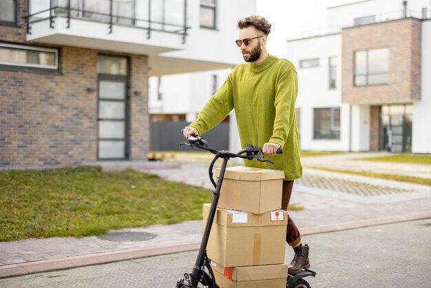 Man drives electric scooter with cardboard packages