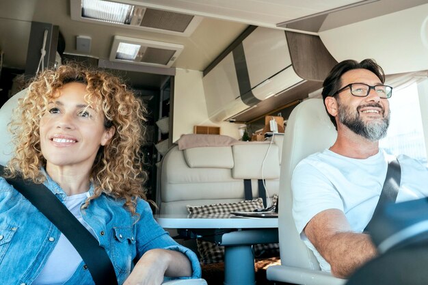 Man driving camper smiles while driving with his wife company concept of travel vacation and life together