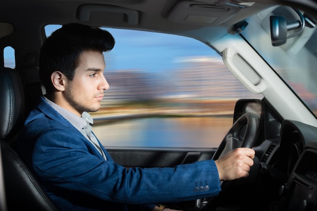 彼の車を運転している男