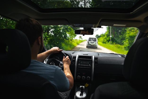 森の小道の道の冒険の時間でsuv車を運転する男