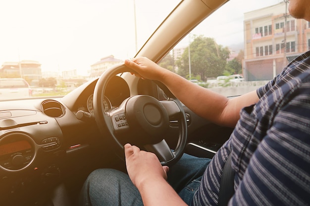 Photo man driving with both hands on steering wheel selective focus. safety driving concept.