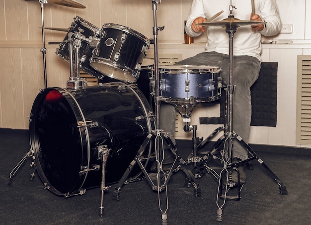 Man drum player hands with sticks and legs on pedal drummer