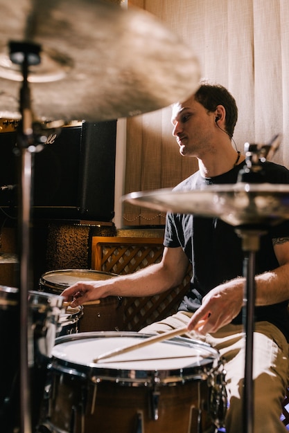 Man drummer playing drums in recording studio