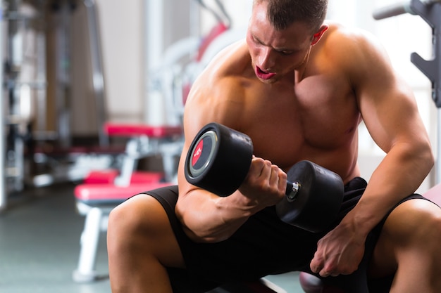 Uomo a dumbbell allenamento in palestra