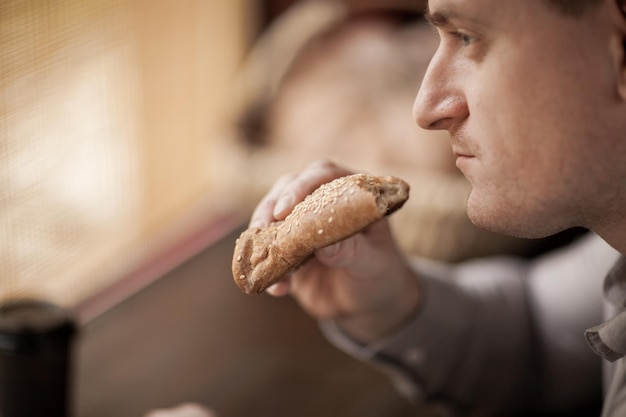 Photo man eating bread in cafe