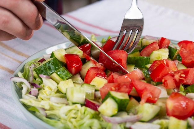 Man eating fresh vegetable salad closeup