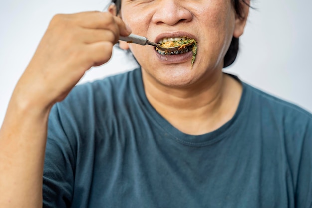 白い背景でガドガドを食べる男 伝統的なインドネシア料理