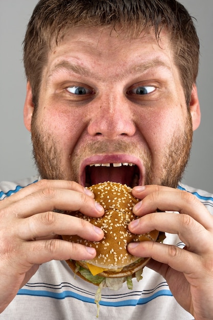 Foto uomo che mangia hamburger