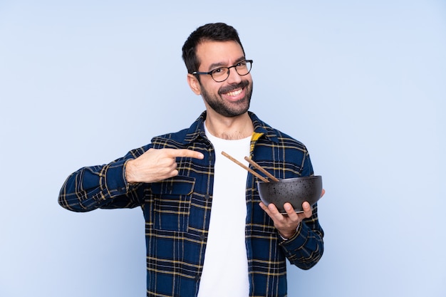 Man eating noodles over isolated wall