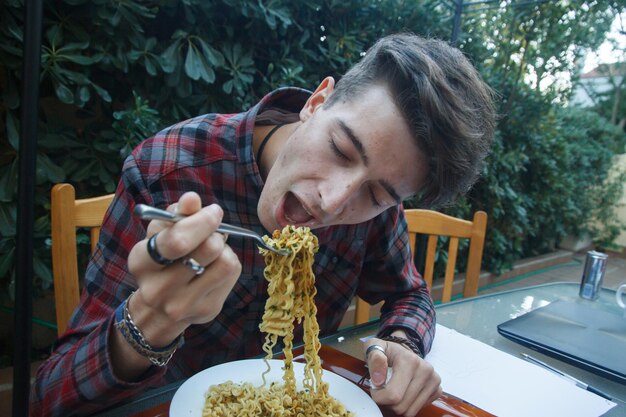 Foto uomo che mangia tagliatelle al ristorante