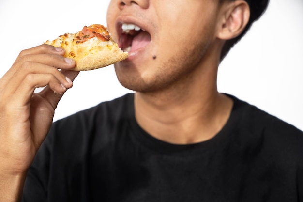 白い背景でピザのスライスを食べる男性