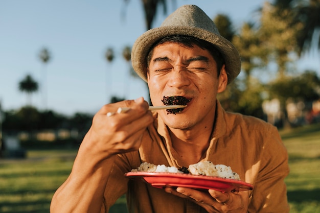 Man eating sushi in the park