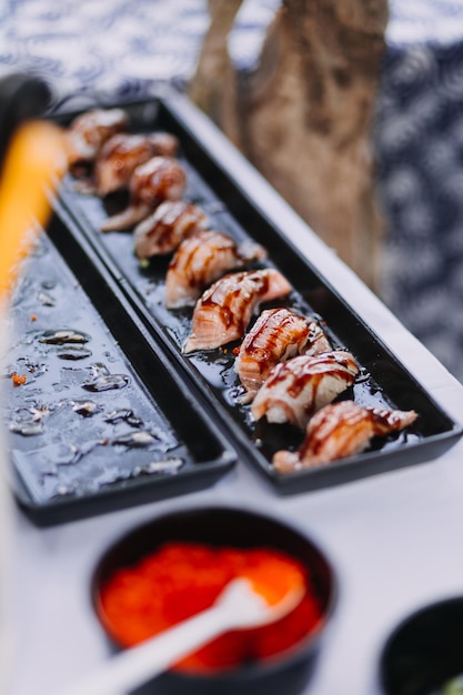 Man eating sushi set with chopsticks on restaurant