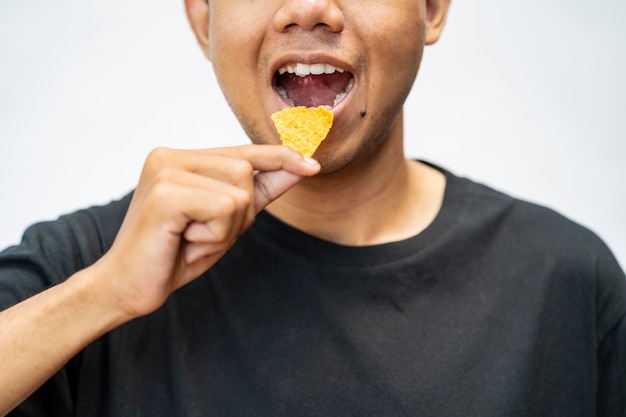 Man eating tortilla chips with a white background