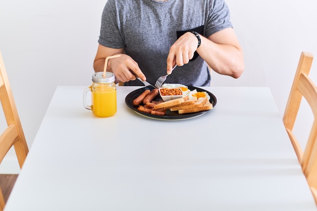 伝統的なフルイングリッシュブレックファストを食べる男