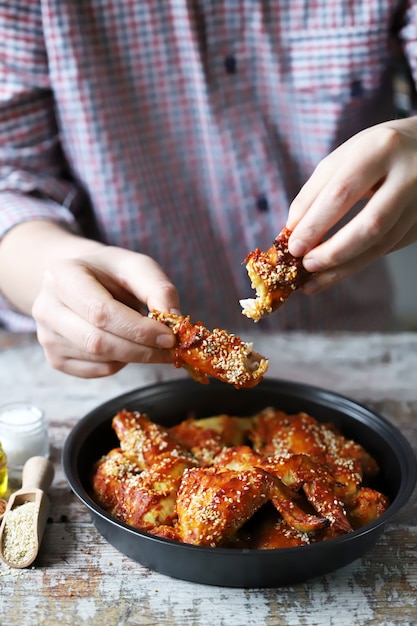 Man eats chicken wings.