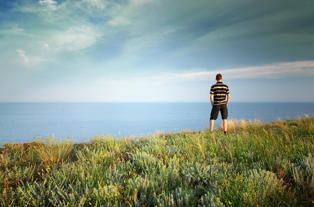 Man on the edge Cliff of mountain and sea Conceptual scene