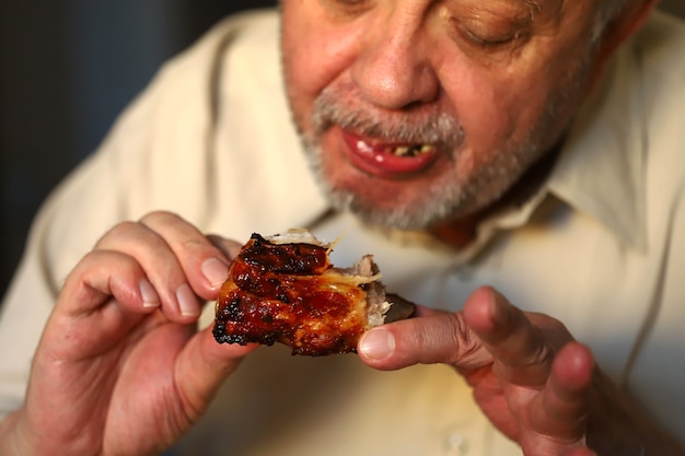 Man eet smakelijke gegrilde varkensribbetjes