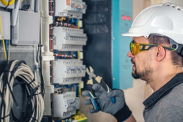 Man an electrical technician working in a switchboard with
fuses