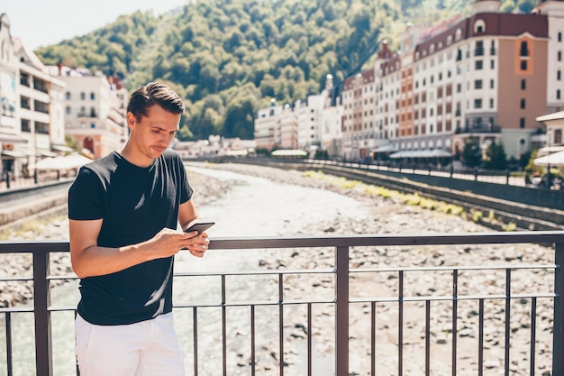 Uomo sull'argine di un fiume di montagna in una città europea.