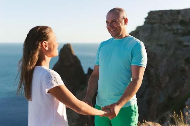 Man embraces a woman on a high mountain overlooking the sea The concept of family love