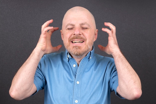 man emotionally holding his hands near his head