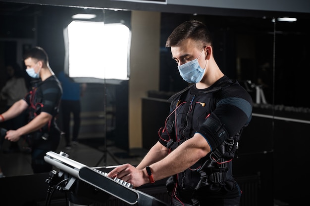 Man in EMS suit and medical mask in gym