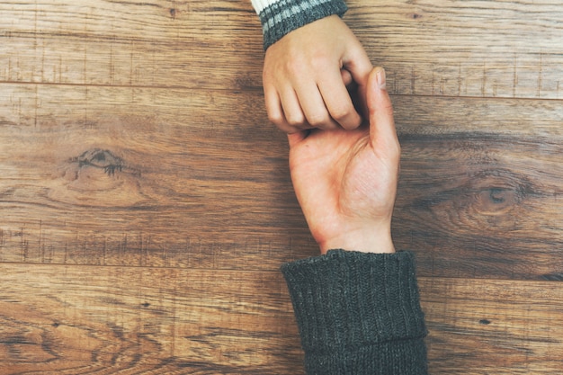 Man en een vrouw hand in hand op een houten tafel