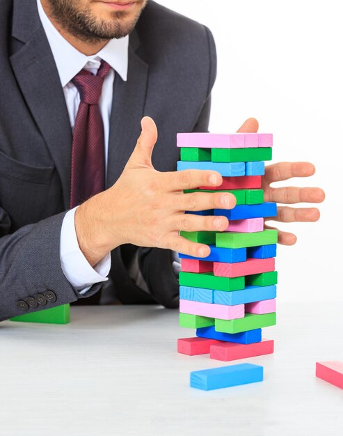 Man en kleurrijke blokkentoren op een wit bureau