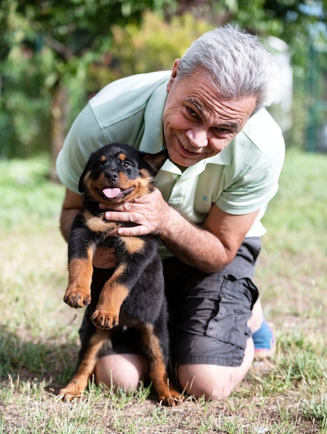 Man en puppy rottweiler voor witte achtergrond