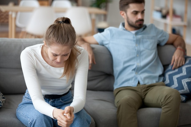 Man en vrouw, boos koppel, samen op de bank thuis.