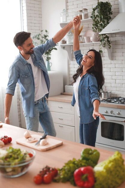 Man en vrouw dansen in de keuken tijdens het bereiden van het diner