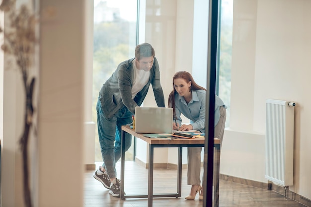 Man en vrouw die aandachtig naar laptop kijken die samenwerken