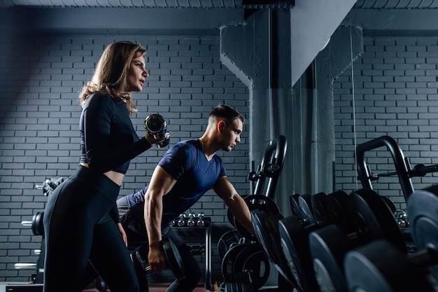 Man en vrouw die halters samen opheffen