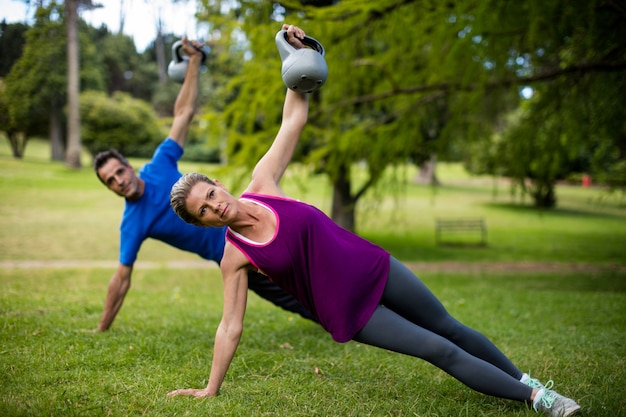 Man en vrouw die met kettlebell uitoefenen