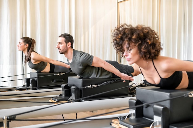 Man en vrouw doen oefening op pilates reformer