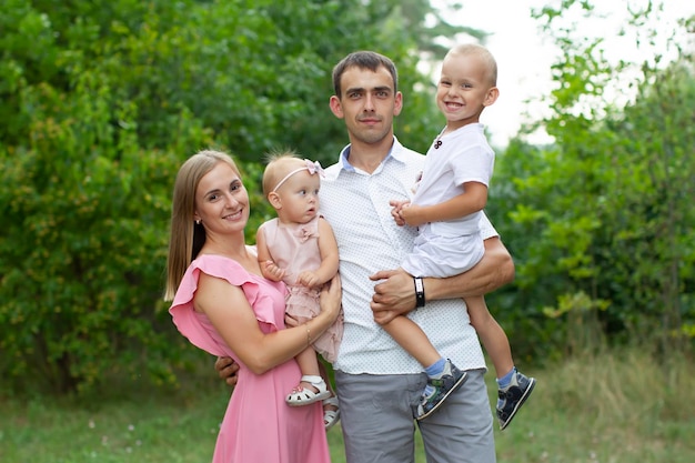 Man en vrouw en hun kleine kinderen familieportret in de natuur