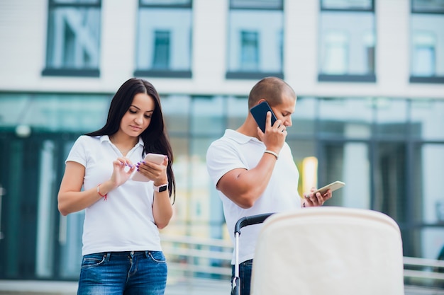 Man en vrouw gebruiken telefoons. kind in rolstoel, concept drukke ouders