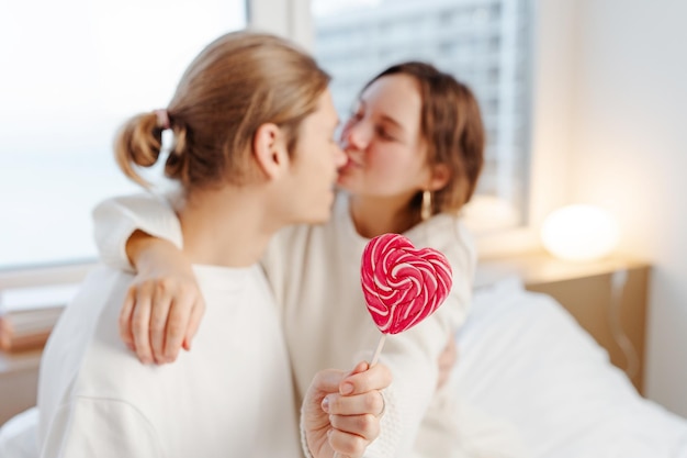 man en vrouw gelukkig paar kussen knuffelen houden lolly thuis selectieve focus liefde