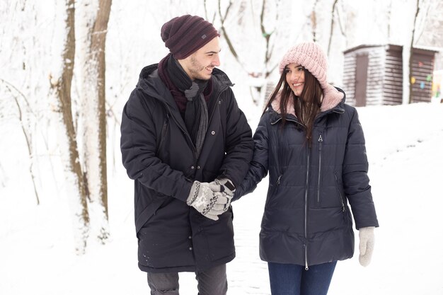 Man en vrouw genieten van winter en sneeuw in park